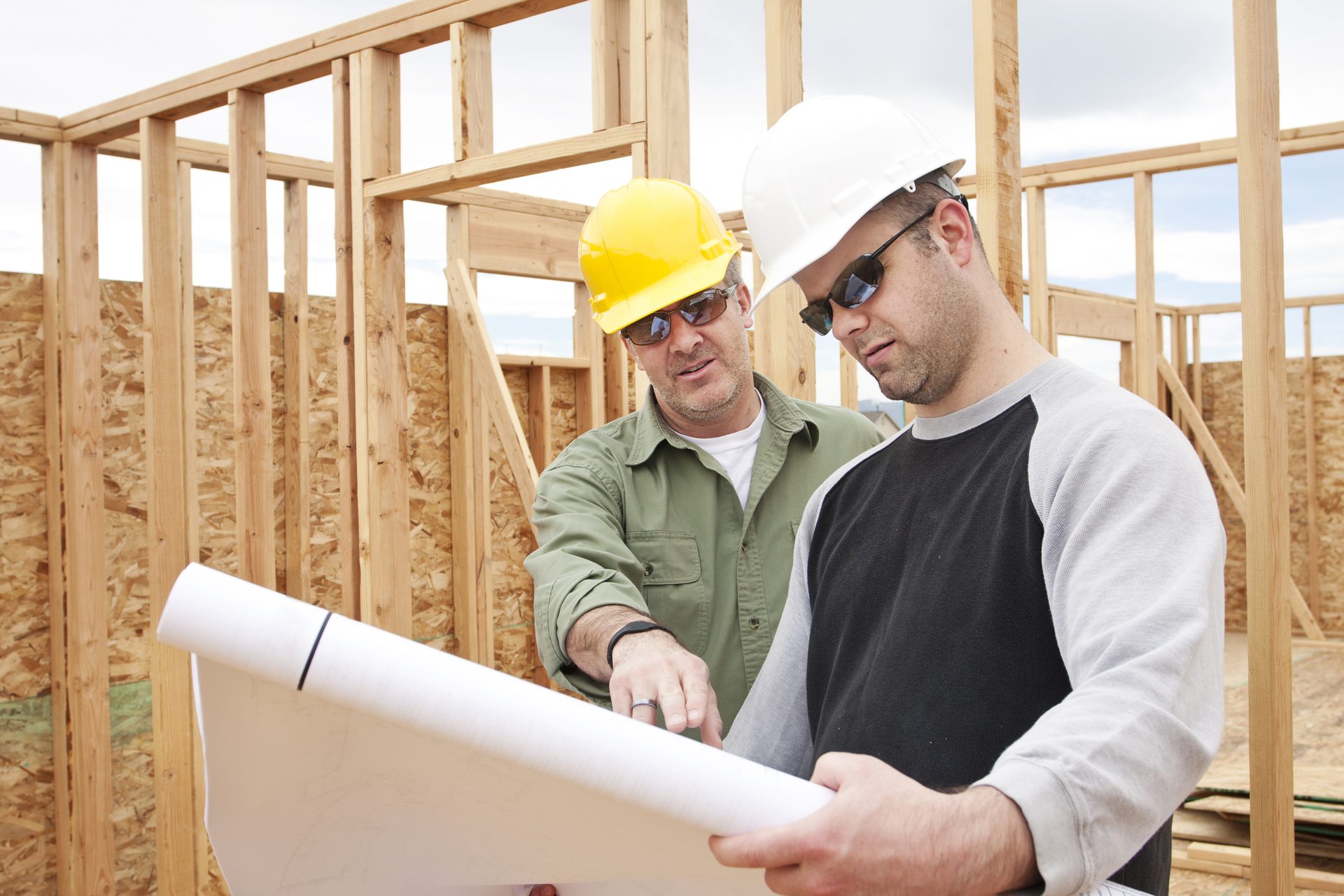Two contractors reviewing blueprints on a framing job site, Midway Supply contractor accounts