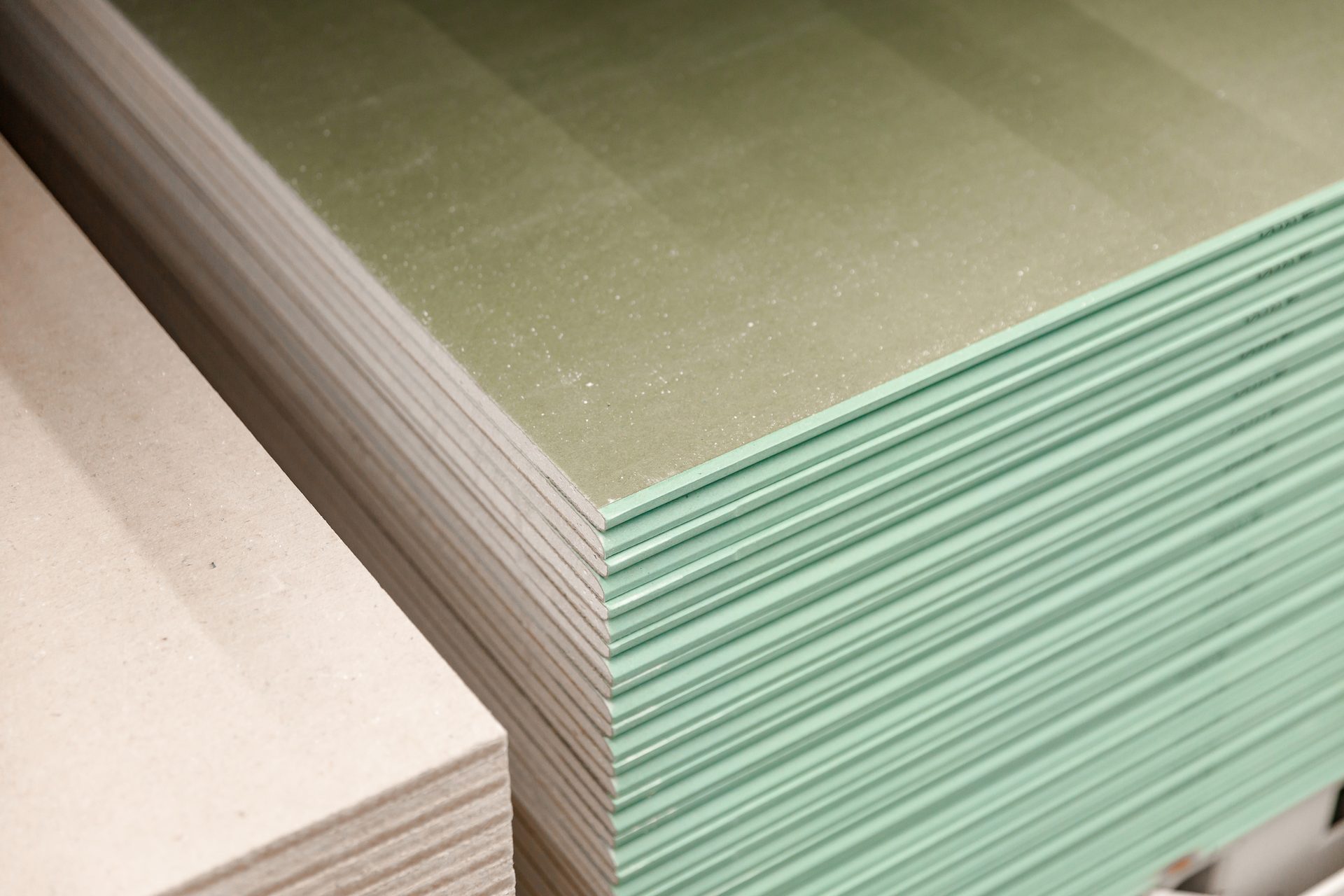 Stacked drywall sheets: standard and moisture-resistant green board