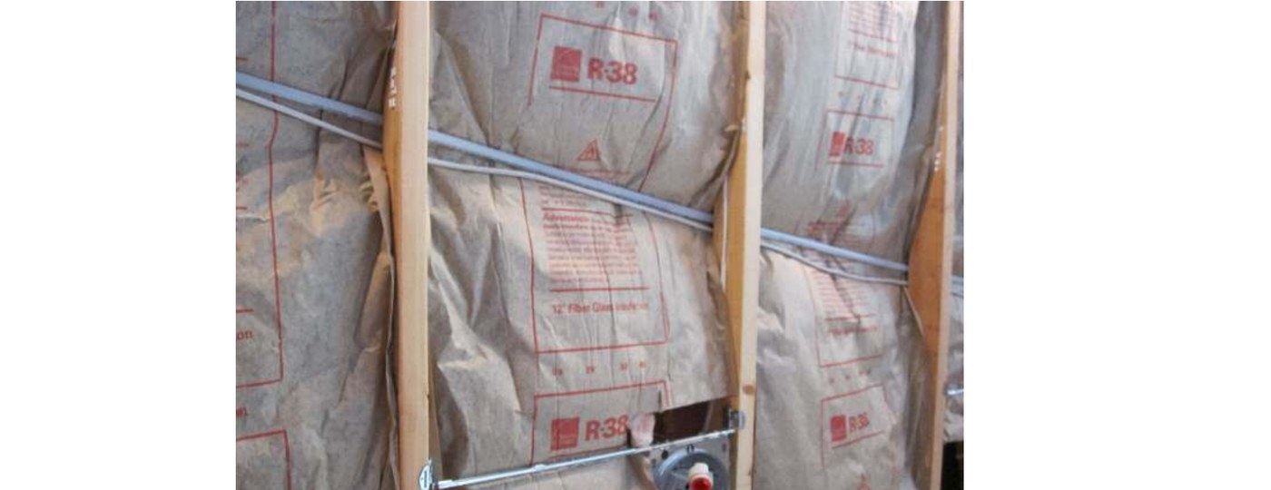 Faced fiberglass batts stuffed behind wiring and compressed in the cavity, the install the rater marks down