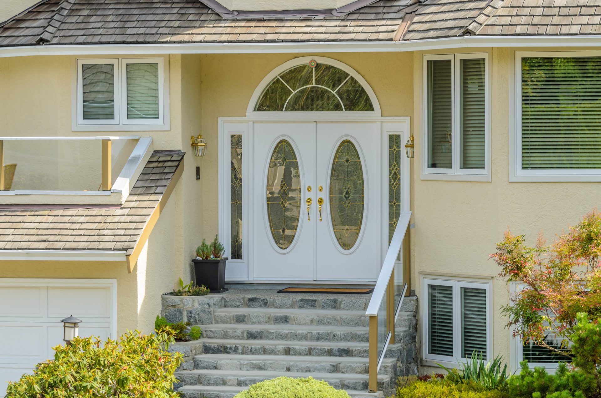 A custom front entry with double oval-glass doors and decorative leaded glass