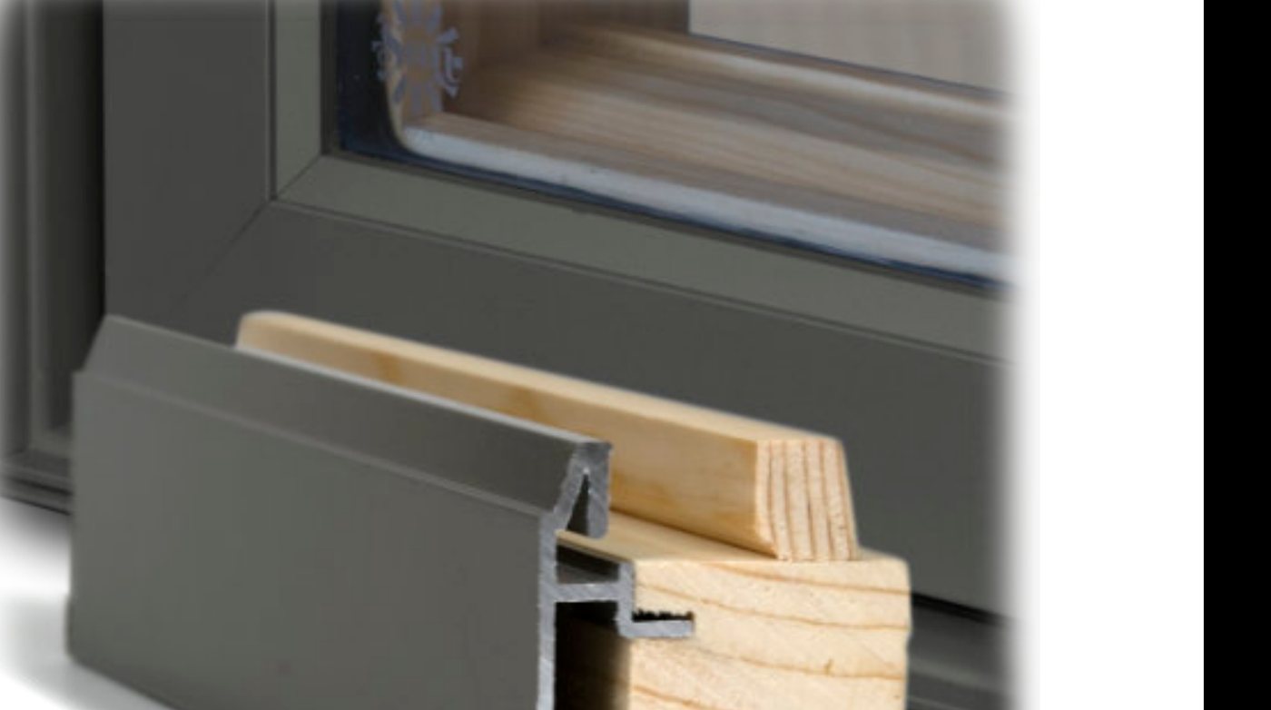 Corner cutaway of a clad-wood window: solid extruded aluminum profile over a clear pine frame