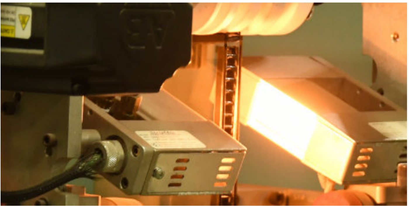 Insulated glass units moving through a factory tempering and sealing line